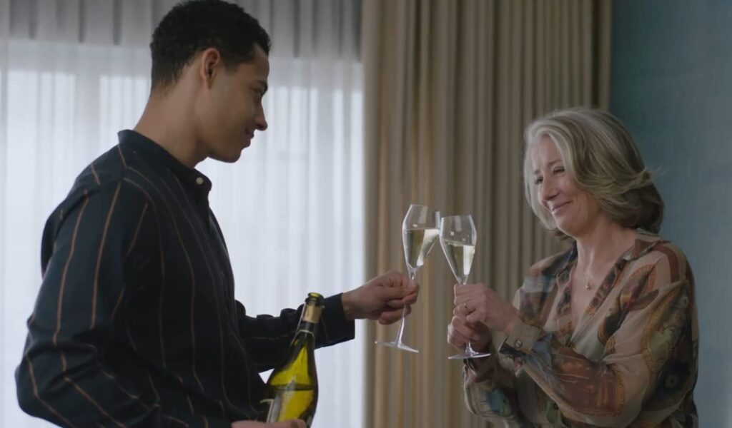 Young man nd older woman cheers wine glasses