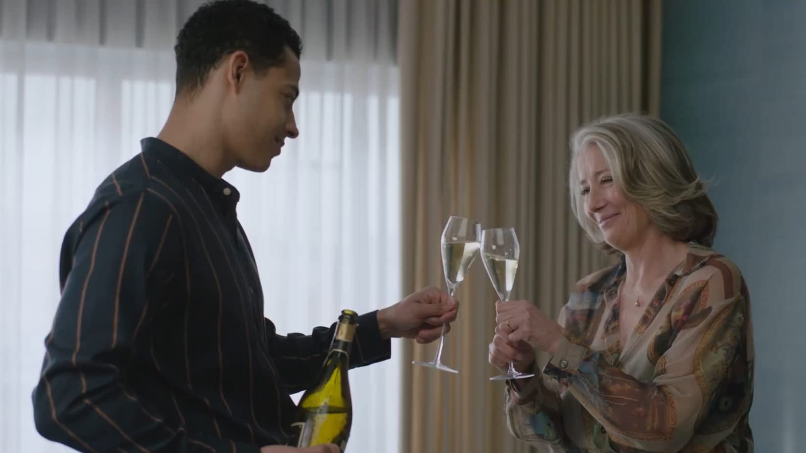 Young man nd older woman cheers wine glasses